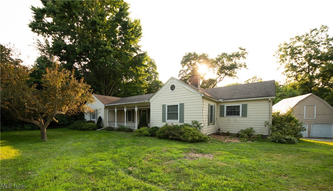 9719 Angling Road Wakeman, OH 44889 - Photo 1 of 39 Rear view of house with covered porch, a yard, a chimney, an outdoor structure, and a detached garage