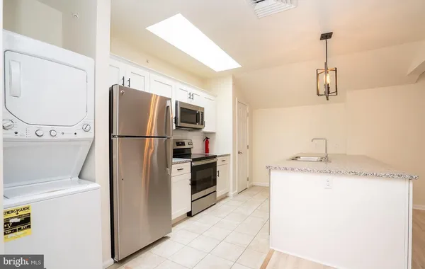 a kitchen with a refrigerator a stove top oven and cabinets