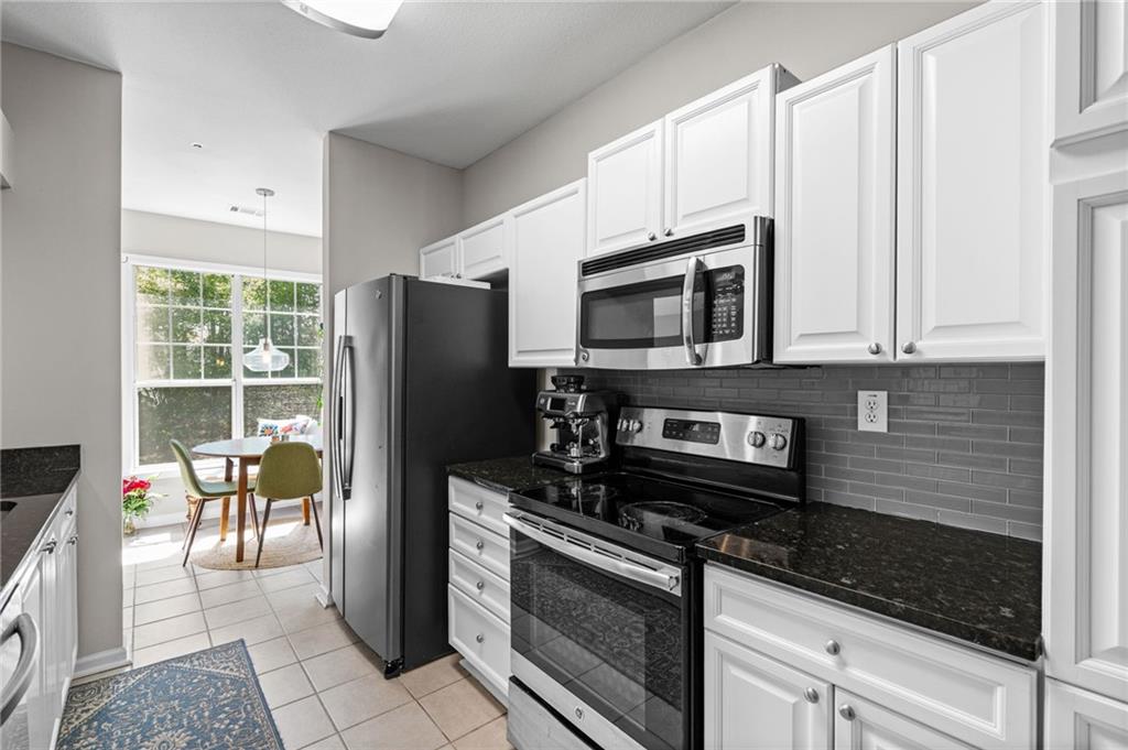 238 Edinburgh Court Alpharetta, GA 30004 - Photo 6 of 20 a kitchen with granite countertop a refrigerator stove and microwave