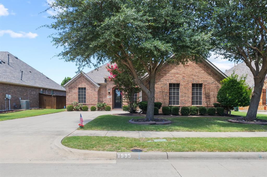 1995 Verde Court Allen, TX 75013 - Photo 28 of 30 Traditional brick exterior with an arched entry, mature shade trees, established landscaping, and a concrete driveway