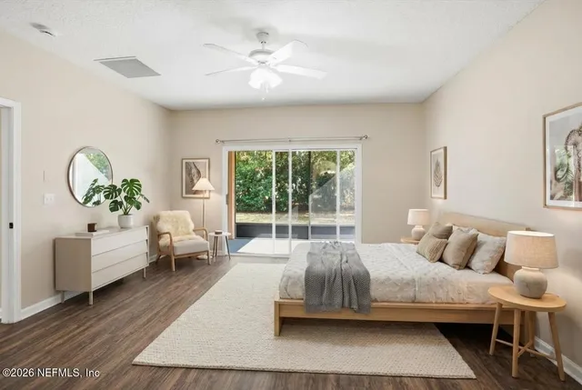 a bedroom with a bed a mirror and lamp