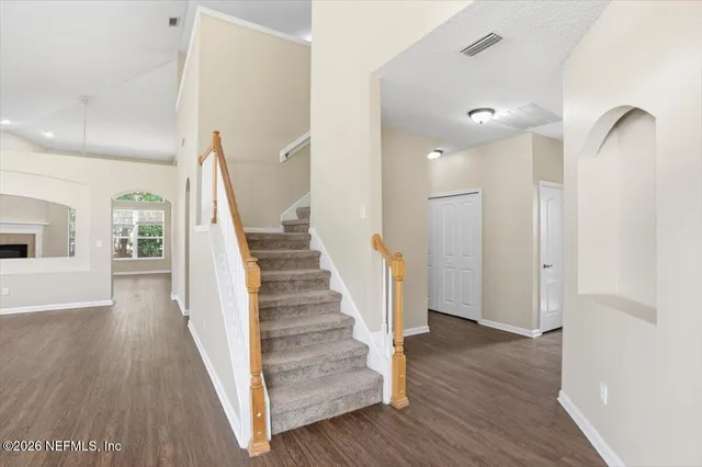 a view of a hallway with wooden floor and staircase