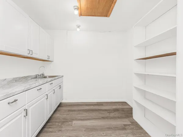 a view of a kitchen with white cabinets and a stove top oven