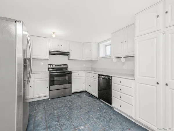 a kitchen with cabinets appliances and a window