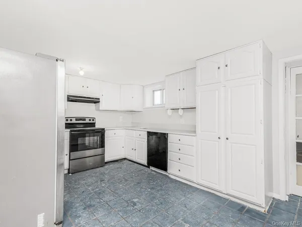 a kitchen with cabinets stainless steel appliances and a window
