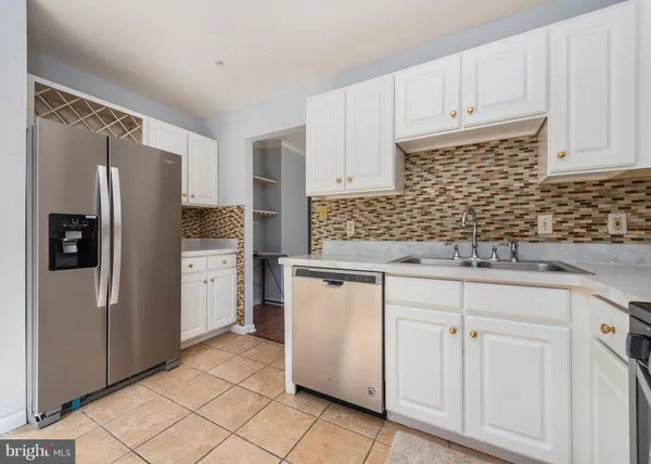 a kitchen with white cabinets and refrigerator