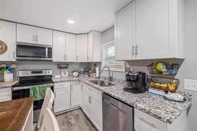 a kitchen with stainless steel appliances granite countertop a sink a stove top oven a counter space and cabinets