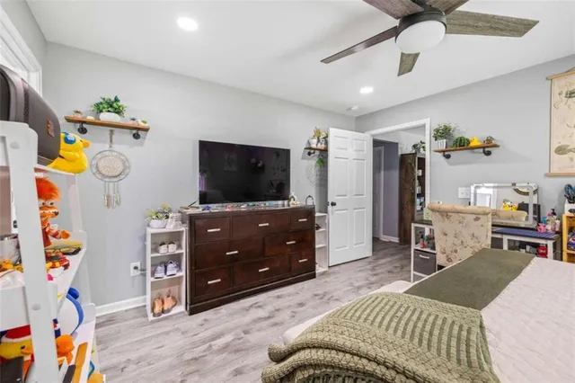 a bedroom with a bed and a flat tv screen on dresser