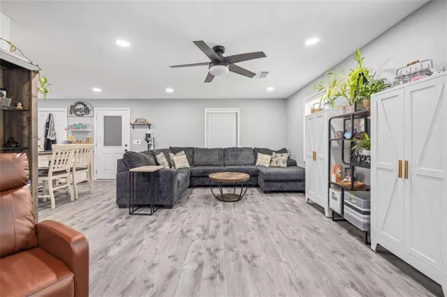 a living room with furniture ceiling fan and a wooden floor