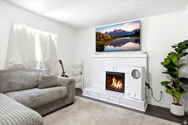 7989 Washington Road Magna, UT 84044 - Photo 21 of 30 Living room featuring a white brick fireplace with a firebox and hearth