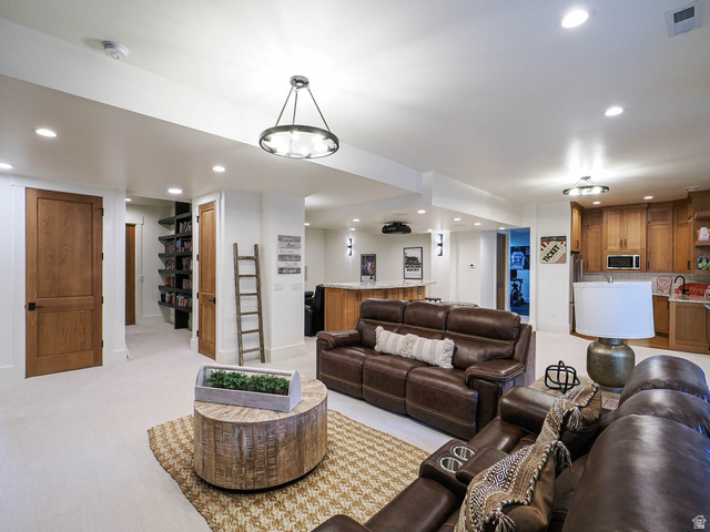3167 South Mapleton Ests Drive Mapleton, UT 84664 - Photo 17 of 30 Recessed lighting and a decorative chandelier illuminate a spacious room featuring a built-in entertainment bar, warm wood cabinetry, and a dedicated shelving alcove
