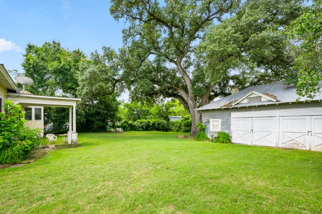 a view of a house with a yard and tree s