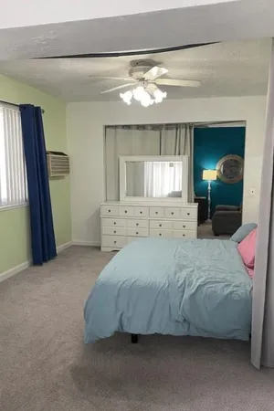 a spacious bedroom with a bed and a mirror