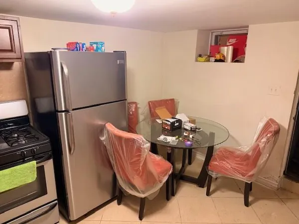 a view of a kitchen with furniture and a refrigerator
