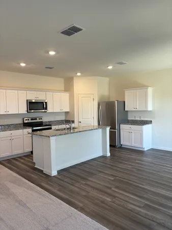 a kitchen with stainless steel appliances granite countertop a stove a sink and a refrigerator
