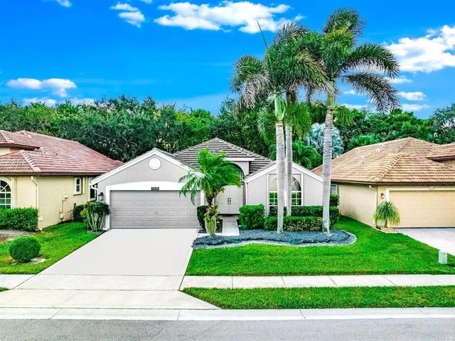 a front view of a house with a yard and potted plants