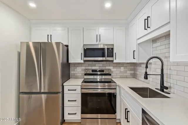 a kitchen with stainless steel appliances a refrigerator stove and microwave