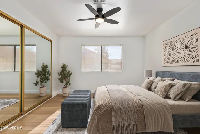 a bedroom with a large bed and a chandelier fan