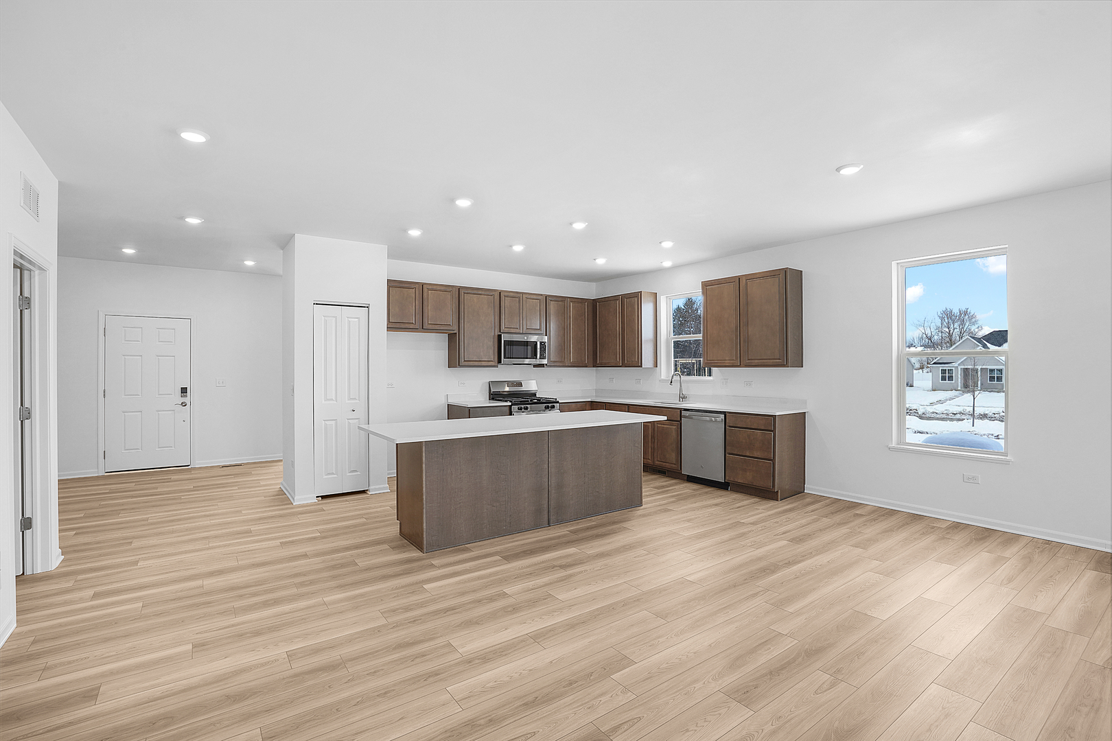 378 Cottrell Lane Aurora, IL 60506 - Photo 9 of 25 a large kitchen with kitchen island a sink wooden floor and stainless steel appliances