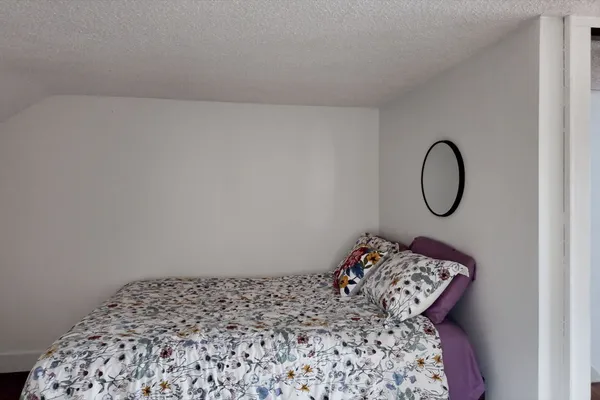 a bed sitting in a bedroom next to a window
