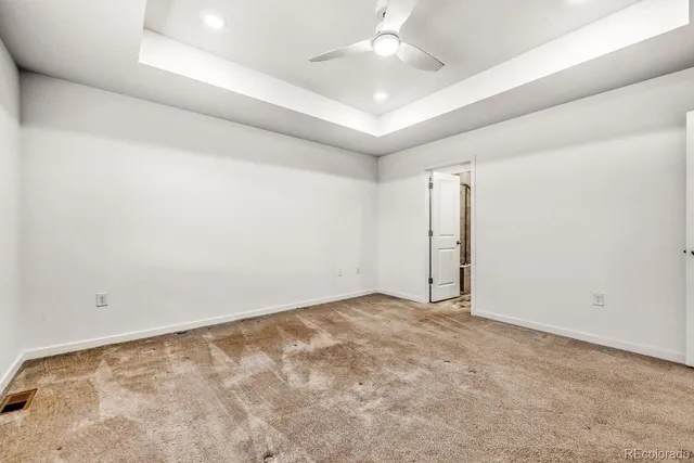 an empty room with a ceiling fan and a window
