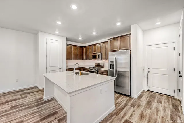 a kitchen with a sink a refrigerator and cabinets