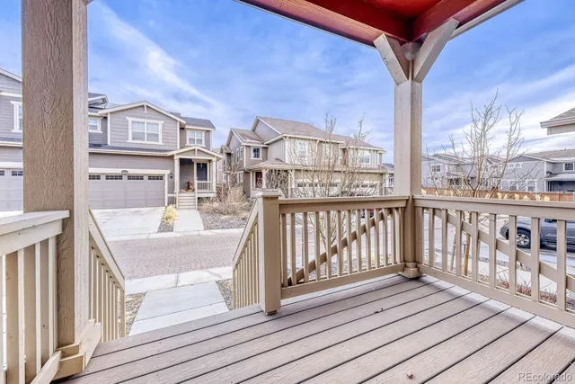 a view of a balcony with wooden floor and iron fence