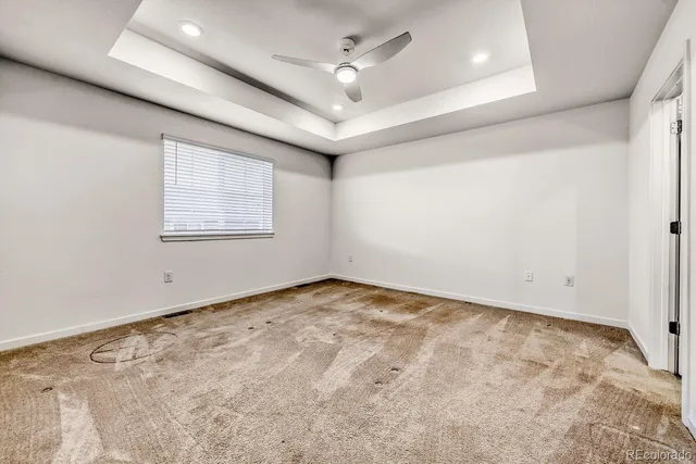 an empty room with windows and ceiling fan