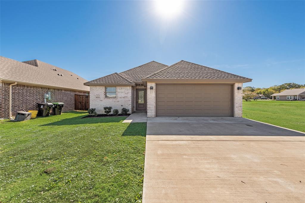 a front view of a house with a garden and yard