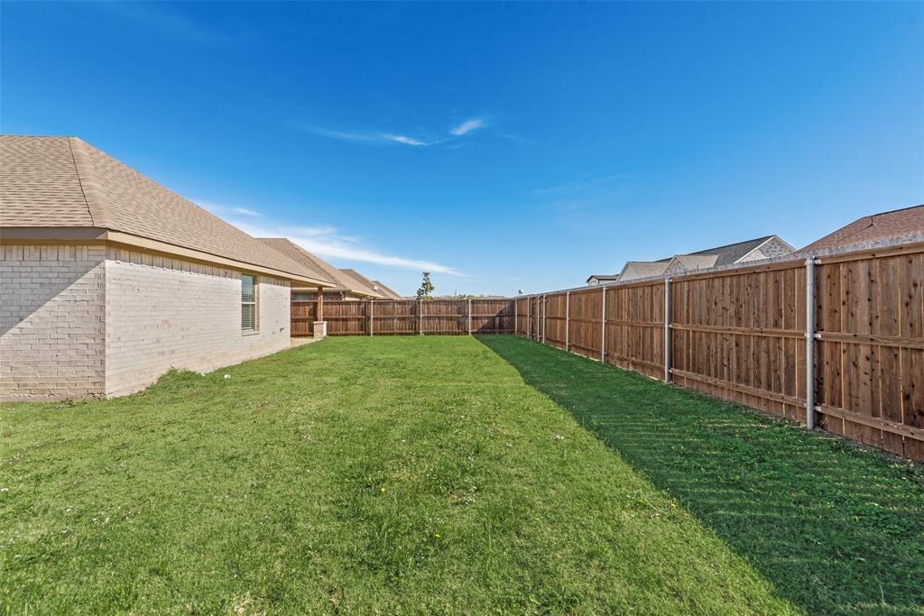 625 Copenhavr Street Pilot Point, TX 76258 - Photo 18 of 20 a view of a backyard with plants and wooden fence