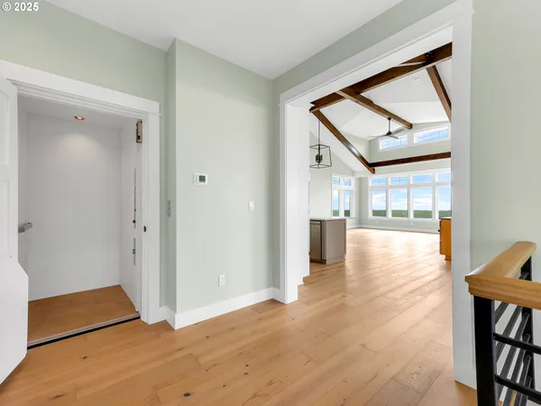a view of a hallway with wooden floor and a dining room