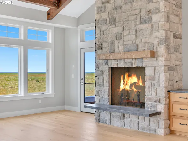 a living room with a fireplace windows and a wooden floor