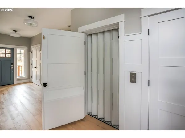 a view of a hallway with wooden floor and closet