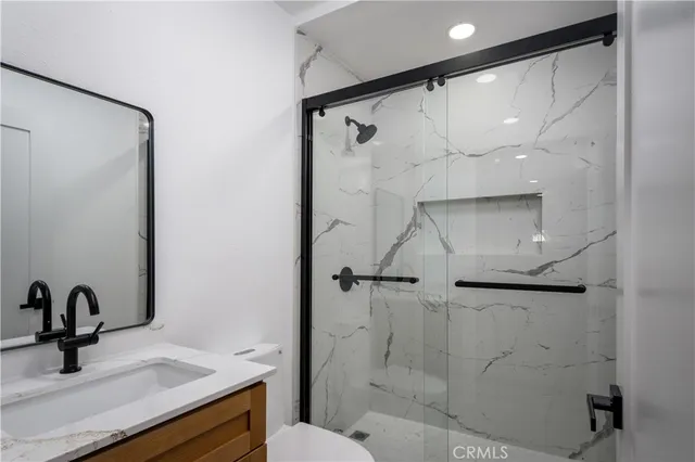 a bathroom with a shower sink and mirror
