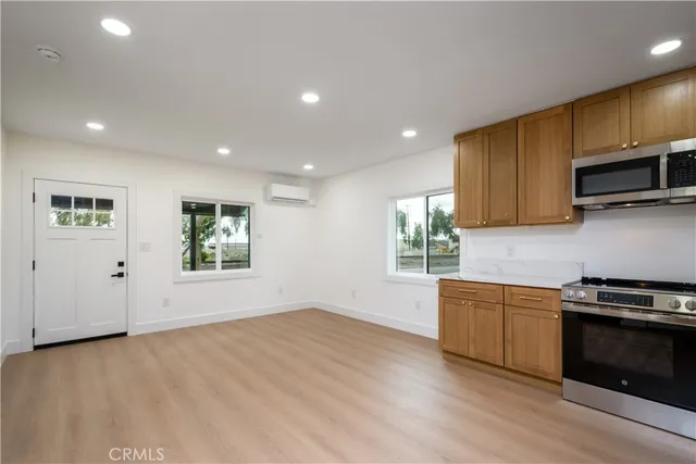 a kitchen with stainless steel appliances granite countertop a stove a sink and a microwave