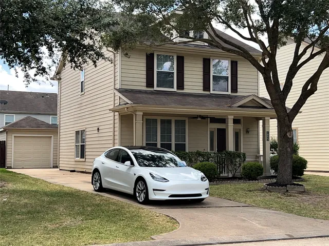 a car parked in front of a white house
