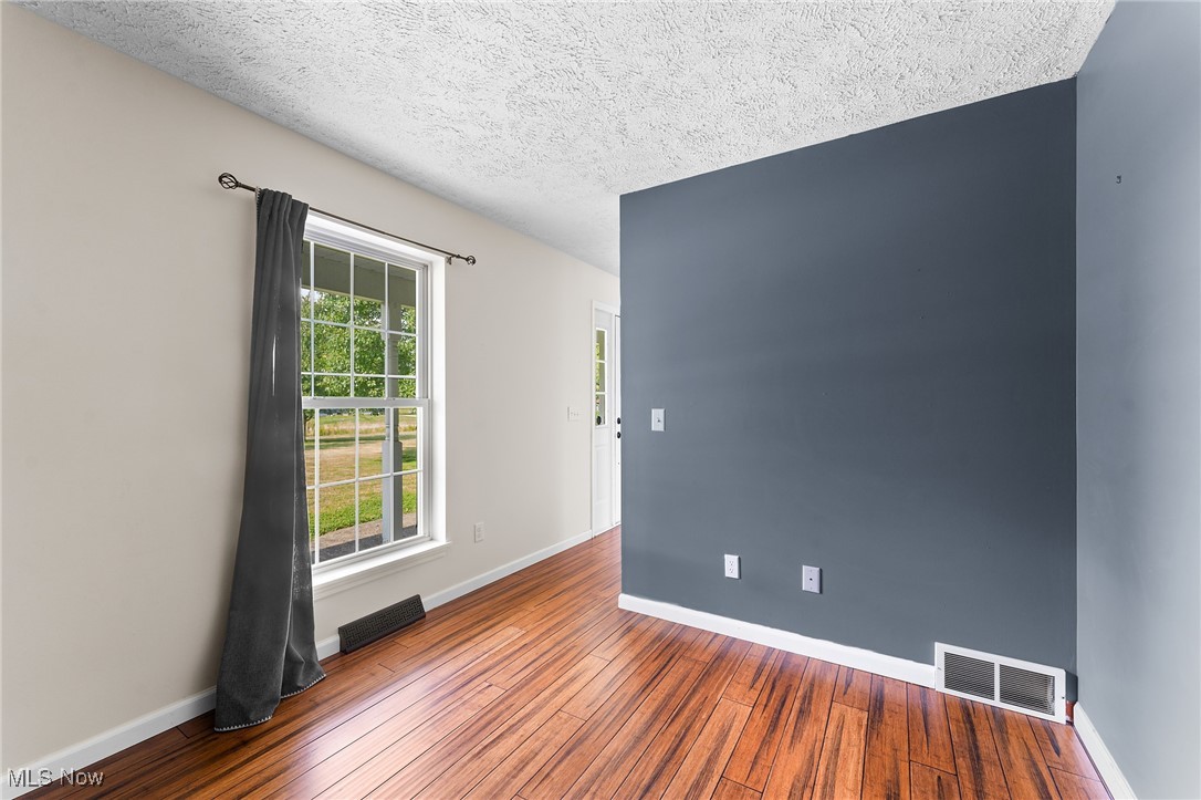 6272 Merwin Chase Road Brookfield, OH 44403 - Photo 14 of 38 Unfurnished room featuring hardwood / wood-style flooring and a textured ceiling
