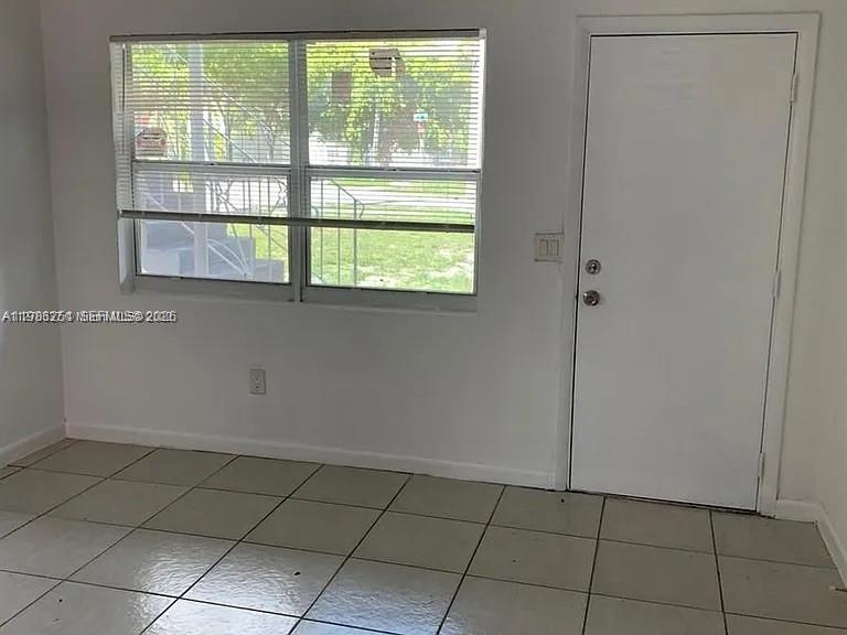 1277 Northwest 58th Street Miami, FL 33142 - Photo 3 of 9 a view of an empty room with a window