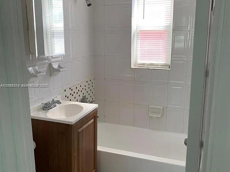 1277 Northwest 58th Street Miami, FL 33142 - Photo 7 of 9 a bathroom with a sink mirror toilet and bathtub