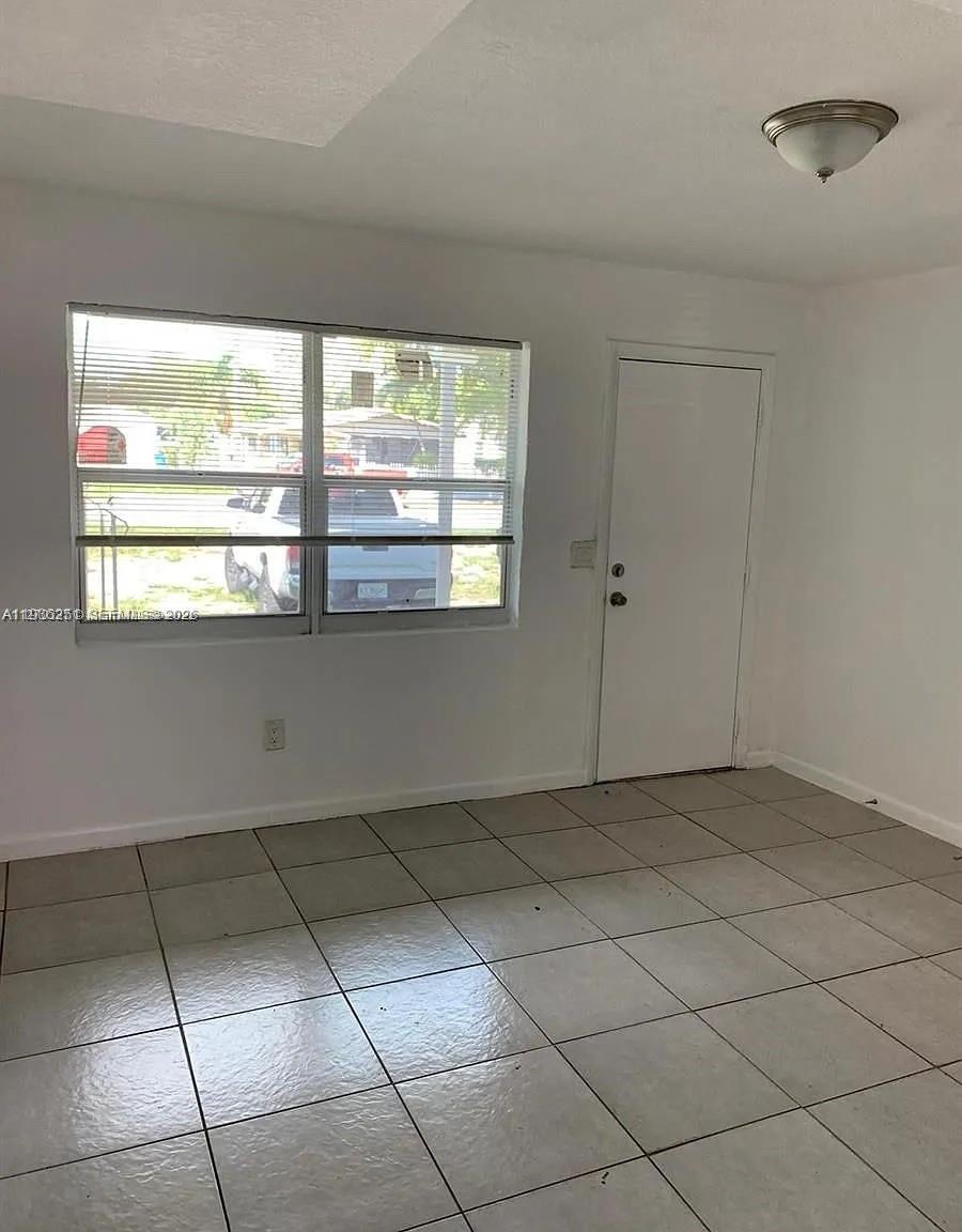 1277 Northwest 58th Street Miami, FL 33142 - Photo 8 of 9 a view of an empty room with a window