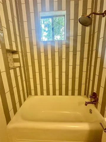 a bathroom with bathtub and shower