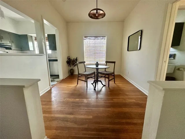 a view of a livingroom with furniture a fireplace wooden floor and windows