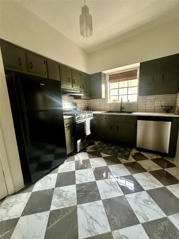 a kitchen with a sink a counter and stainless steel appliances