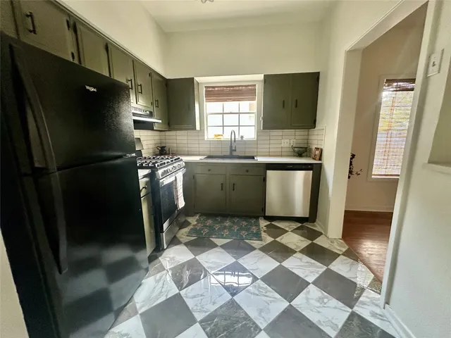 a kitchen with stainless steel appliances granite countertop a refrigerator and a sink