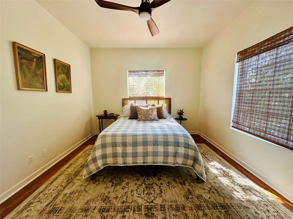 1700 Houston Street, Unit 201 Austin, TX 78756 - Photo 20 of 26 a bedroom with a bed and wooden floor