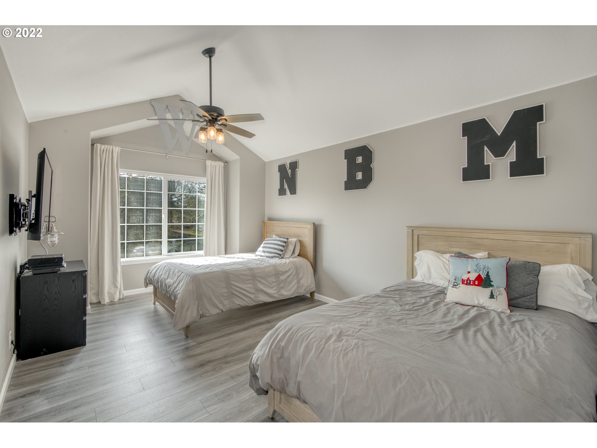 10463 Southwest Laurel Road Beaverton, OR 97005 - Photo 23 of 28 a bedroom with two beds and a chandelier