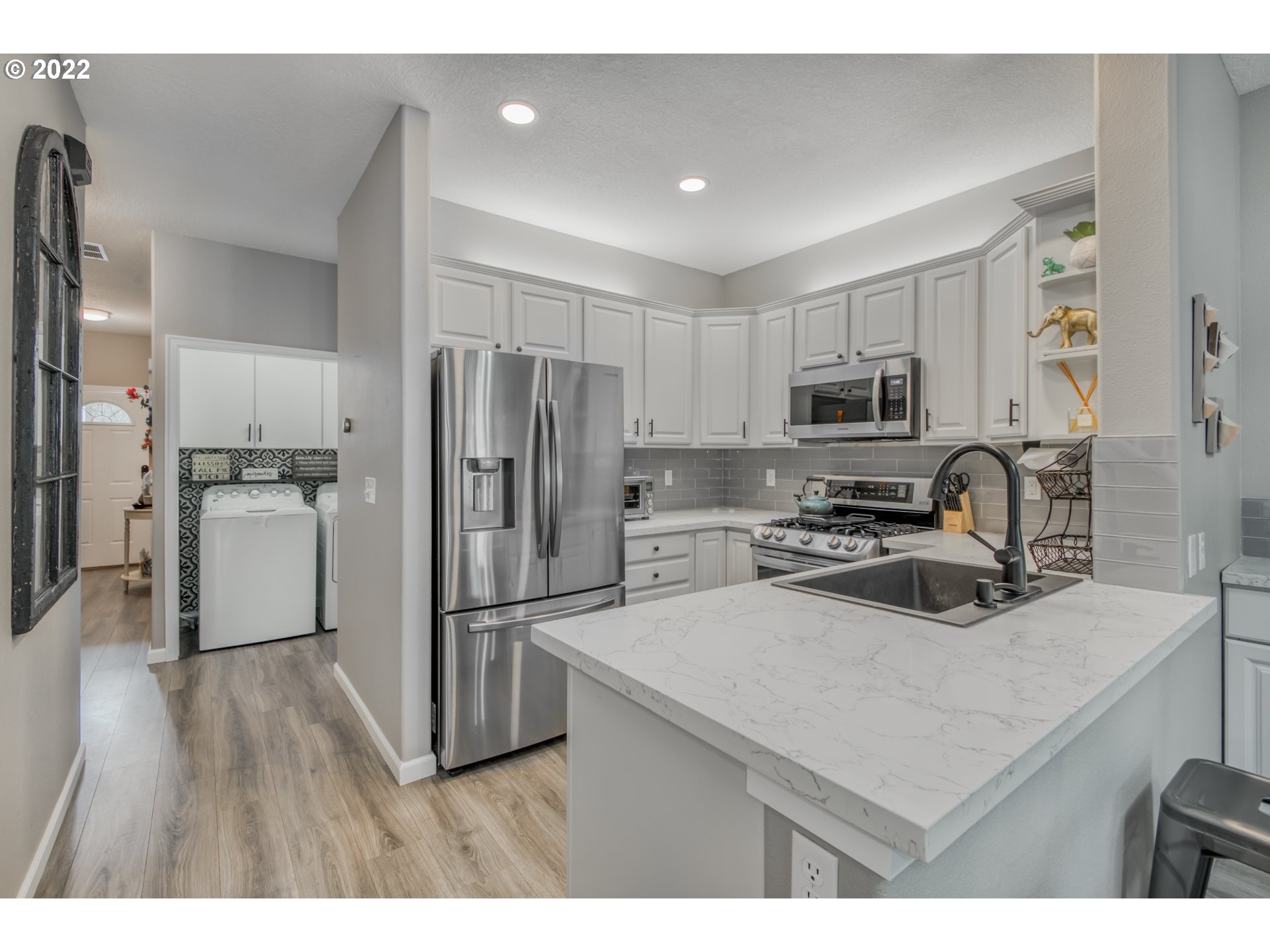 10463 Southwest Laurel Road Beaverton, OR 97005 - Photo 7 of 28 a kitchen with wooden cabinets and stainless steel appliances