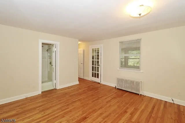 a view of a livingroom with wooden floor and a window