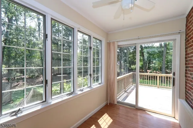 a view of empty room with wooden floor and windows