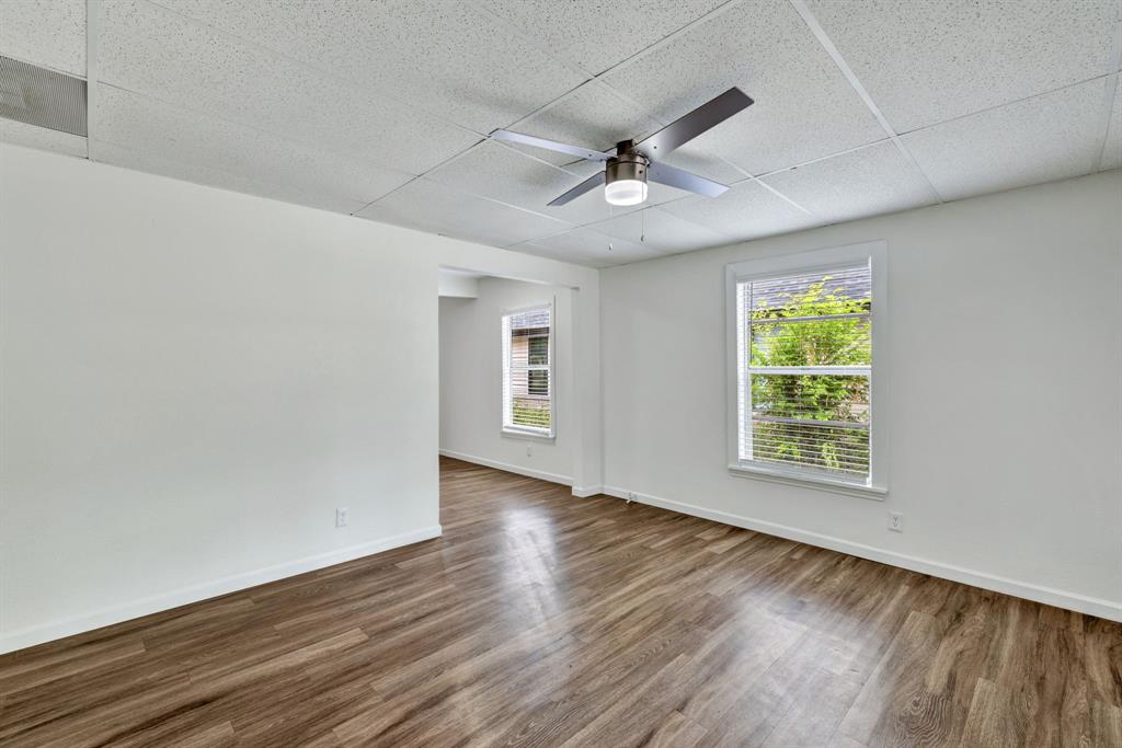 613 Cheyenne Road Dallas, TX 75217 - Photo 12 of 28 Spacious room featuring wood-finish flooring, crisp white walls, and a contemporary ceiling fan with integrated lighting